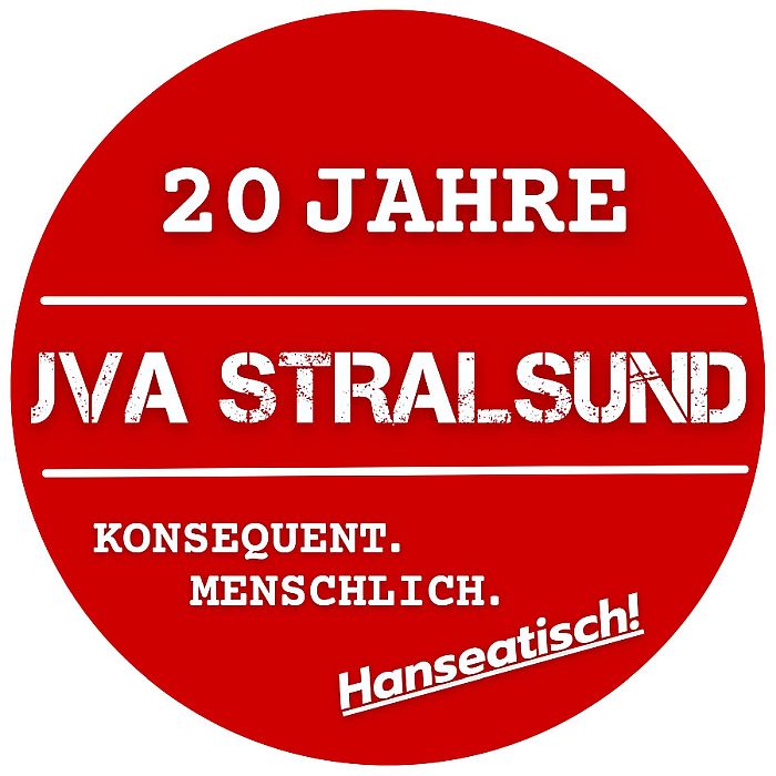 Ein roter Aufkleber mit weißer Schrift: 20 Jahre JVA Stralsund Konsequent Menschlich Hanseatisch