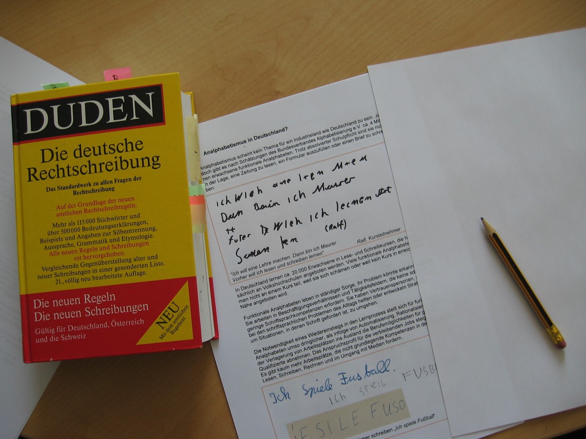 Ein Duden liegt auf dem Tisch. Daneben liegt ein Bleistift und ein Arbeitsblatt.