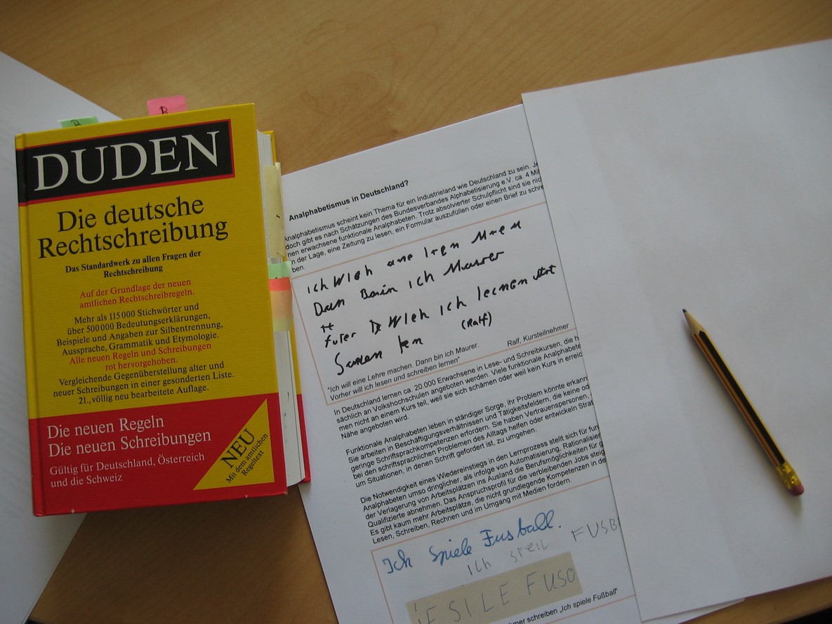 Ein Duden liegt auf dem Tisch. Daneben liegt ein Bleistift und ein Arbeitsblatt. (Interner Link: Bildung & Freizeit)