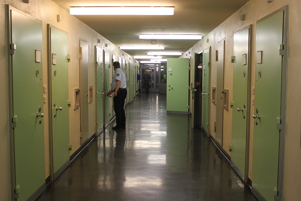 Vollzugsbeamter öffnet Haftraumtür